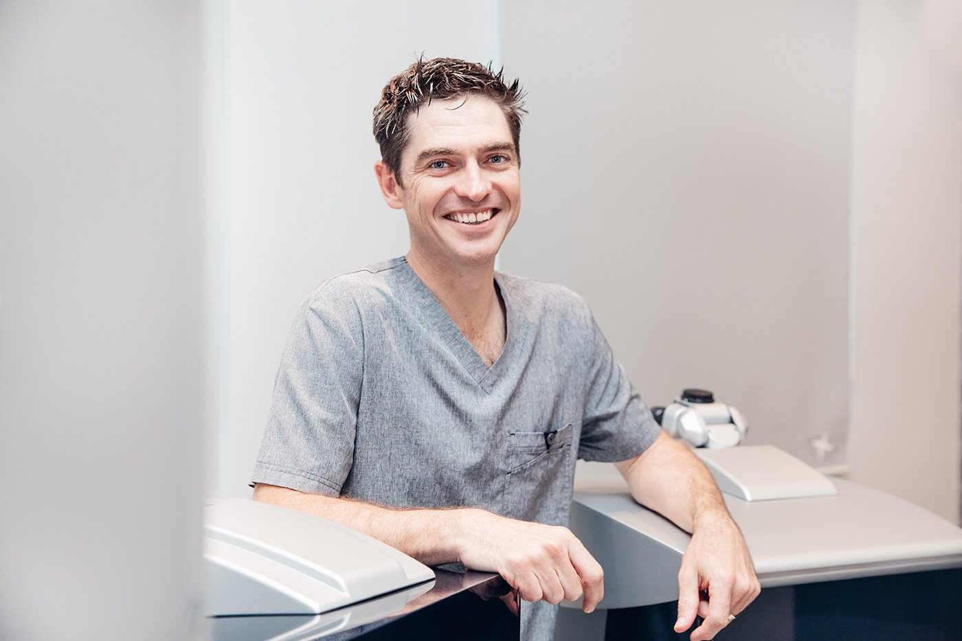 Dr Dylan Joseph in the clinic, beside the examination equipment